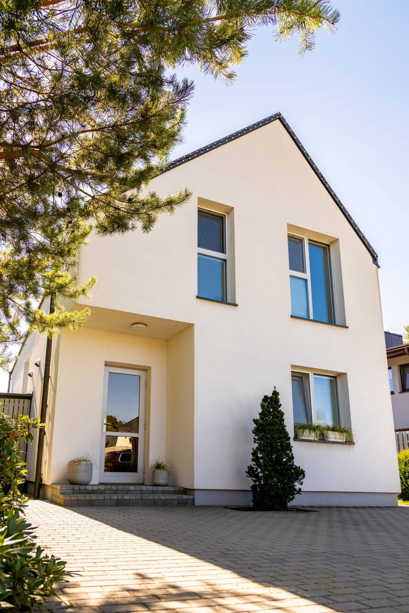 Modernt vitt hus med enkel fasadrenovering och stilren entré.